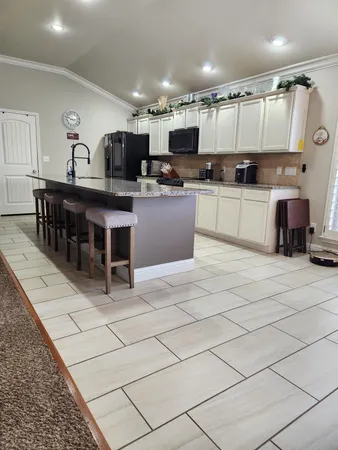 a kitchen with stainless steel appliances kitchen island granite countertop a sink and cabinets