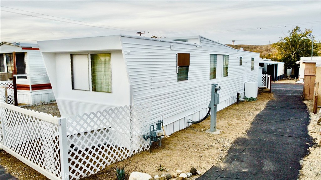 6426 Valley View Street, Unit 9 Joshua Tree, CA 92252 - Photo 2 of 23 a view of a white house with wooden fence