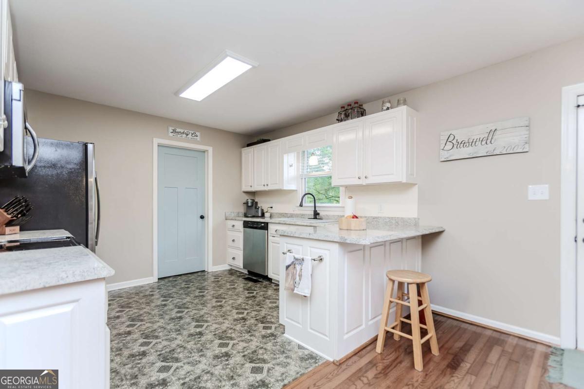 6441 Hog Mountain Road Bogart, GA 30622 - Photo 11 of 57 a kitchen with a sink cabinets and wooden floor