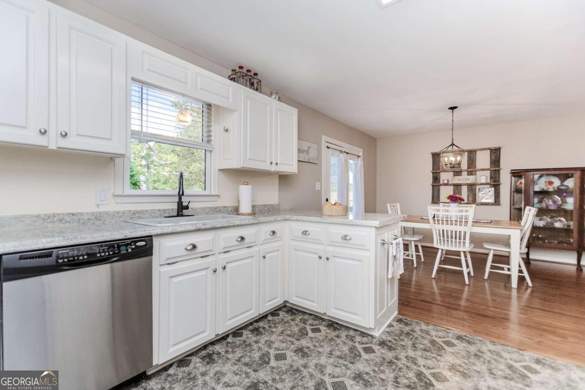 6441 Hog Mountain Road Bogart, GA 30622 - Photo 12 of 57 a kitchen with a white cabinets and chairs