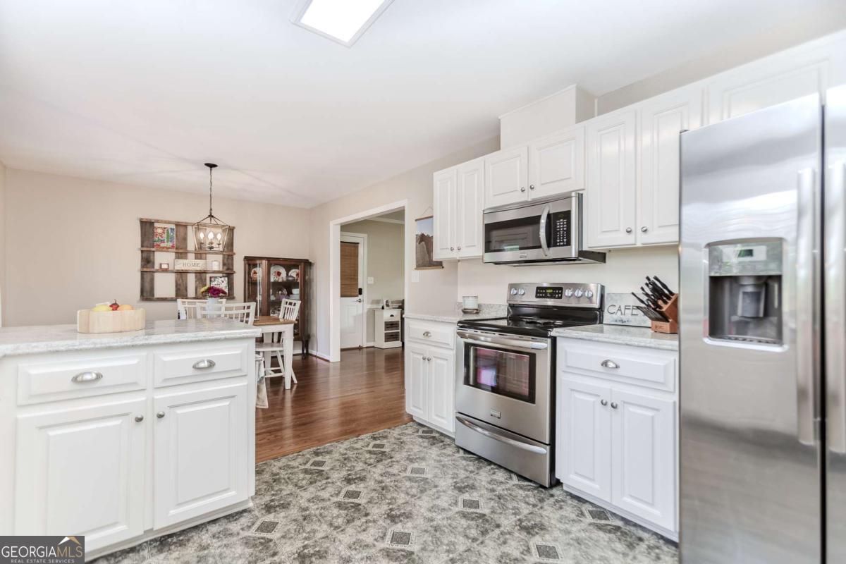 6441 Hog Mountain Road Bogart, GA 30622 - Photo 13 of 57 a kitchen with white cabinets and stainless steel appliances