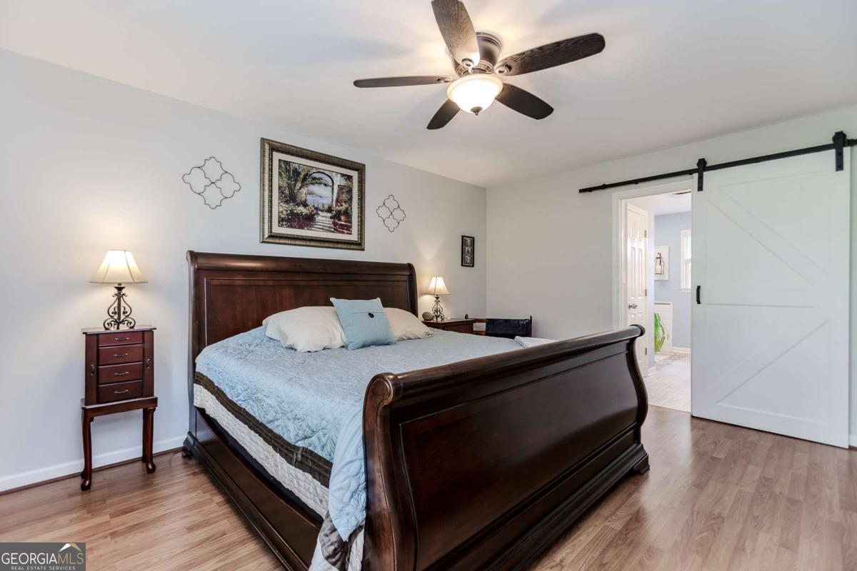 6441 Hog Mountain Road Bogart, GA 30622 - Photo 17 of 57 a bedroom with a bed and a chandelier