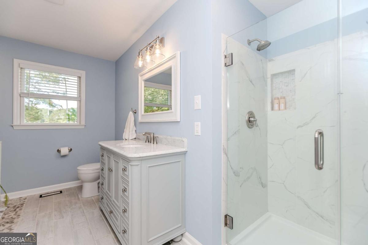 6441 Hog Mountain Road Bogart, GA 30622 - Photo 18 of 57 a bathroom with a granite countertop sink a toilet and shower