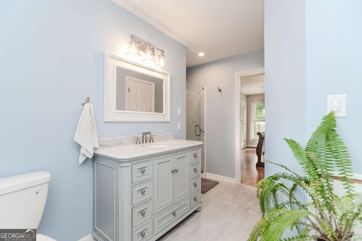 6441 Hog Mountain Road Bogart, GA 30622 - Photo 21 of 57 a bathroom with a granite countertop sink a toilet and a mirror
