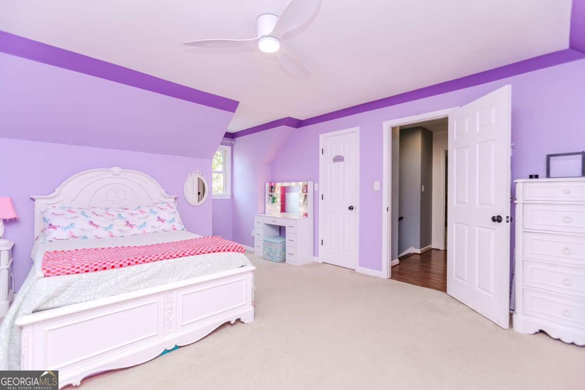 6441 Hog Mountain Road Bogart, GA 30622 - Photo 24 of 57 a spacious bedroom with a bed and a chandelier