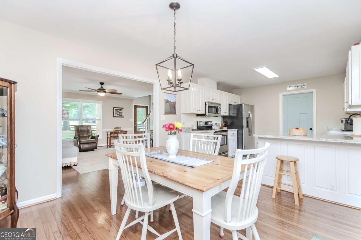 6441 Hog Mountain Road Bogart, GA 30622 - Photo 9 of 57 a view of a dining room and livingroom with furniture wooden floor kitchen view and dining table