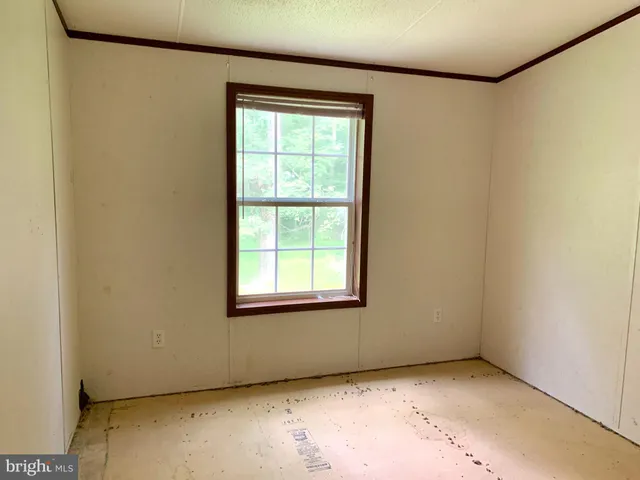 a view of an empty room with closet and a bathroom
