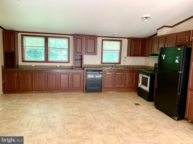 a kitchen with stainless steel appliances granite countertop a refrigerator a stove a sink dishwasher and wooden cabinets