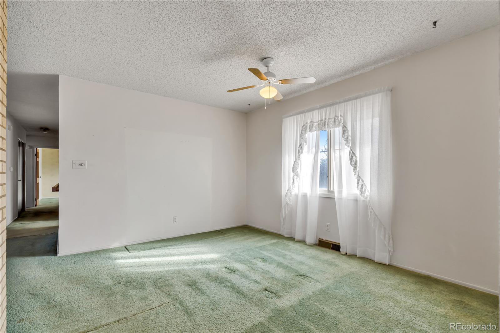 754 Highway 86 Elizabeth, CO 80107 - Photo 14 of 47 an empty room with chandelier fan and windows