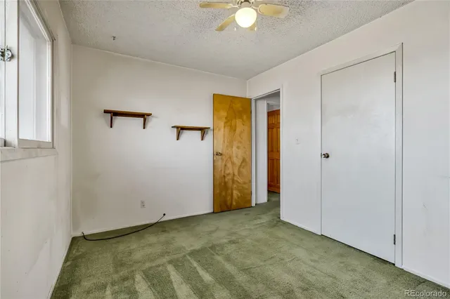 an empty room with windows and closet