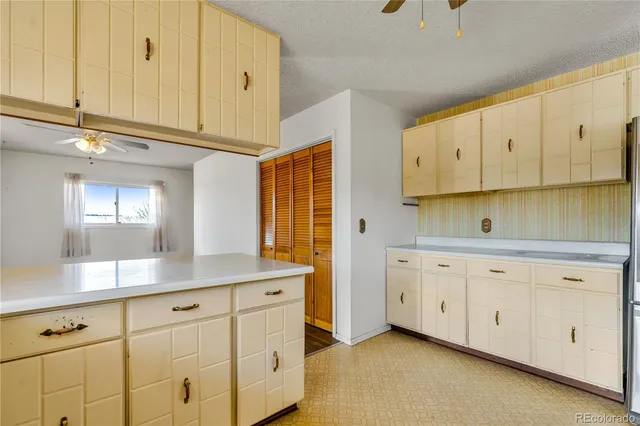 a kitchen with granite countertop white cabinets and a sink