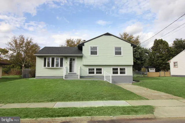 a front view of a house with a yard and trees