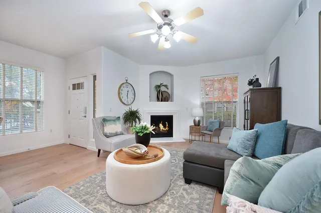 a living room with furniture a fireplace and a chandelier