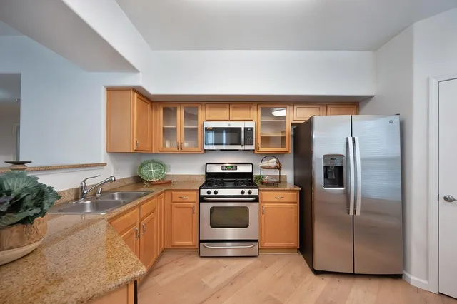 a kitchen with stainless steel appliances a refrigerator sink and stove