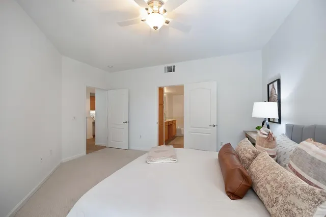 a spacious bedroom with a bed and a chandelier