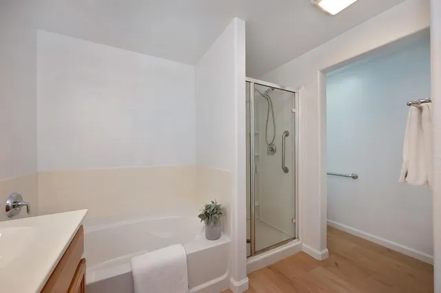 a bathroom with a tub shower and hallway