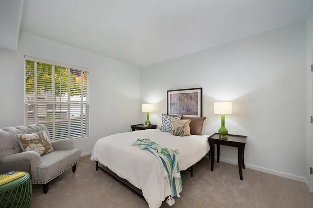 a bedroom with a bed a couch and a window