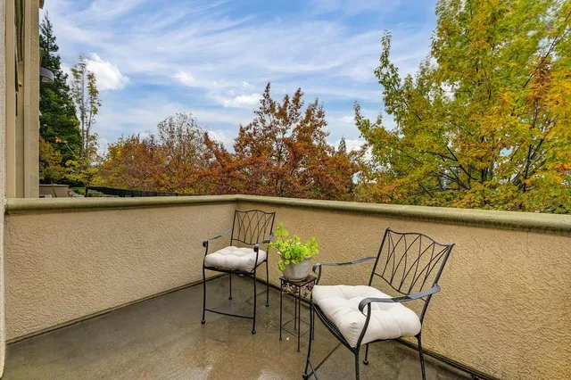 a balcony with wooden floor and outdoor seating