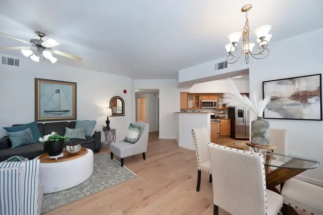 a living room with furniture a chandelier and a mirror