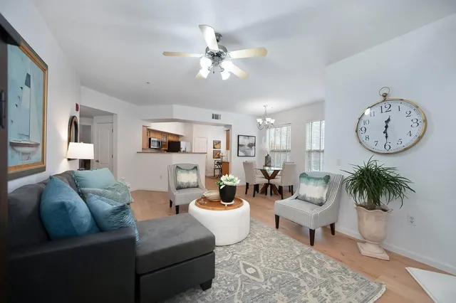 a living room with furniture a clock and a flat screen tv