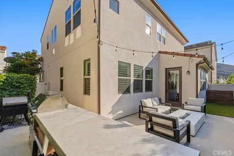 a view of a patio with couches table and chairs and potted plants