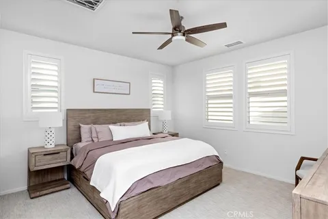 a bedroom with a bed a chandelier and a window