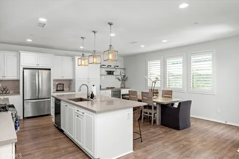 a kitchen with stainless steel appliances granite countertop a sink stove and refrigerator