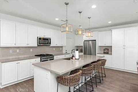 a kitchen with kitchen island granite countertop a sink a center island and stainless steel appliances