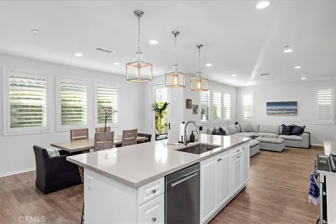 a large kitchen with kitchen island a sink a counter space and living room view