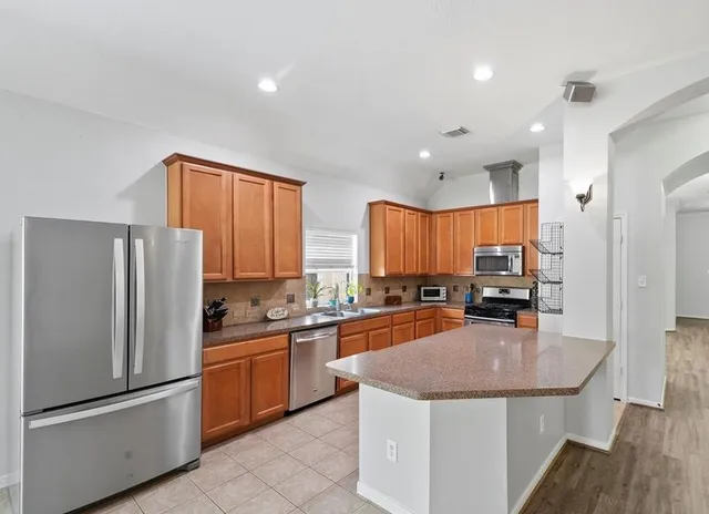 a kitchen with stainless steel appliances granite countertop a sink stove and refrigerator