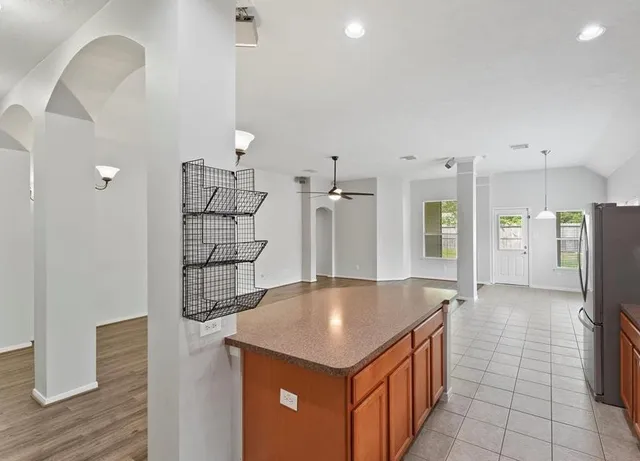 an open kitchen with granite countertop a sink and a refrigerator