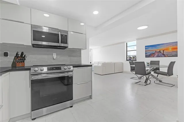 a kitchen with stainless steel appliances a stove a sink a microwave and cabinets