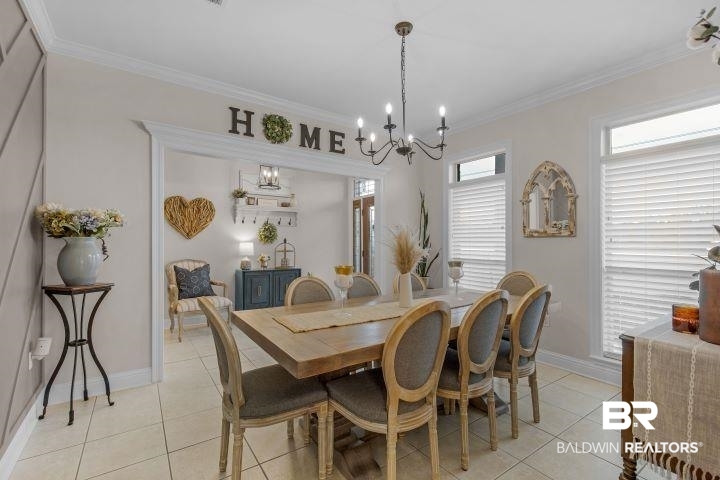 24541 Baldwin Beach Expressway Robertsdale, AL 36567 - Photo 13 of 51 Dining space with light tile patterned flooring, ornamental molding, baseboards, and a notable chandelier