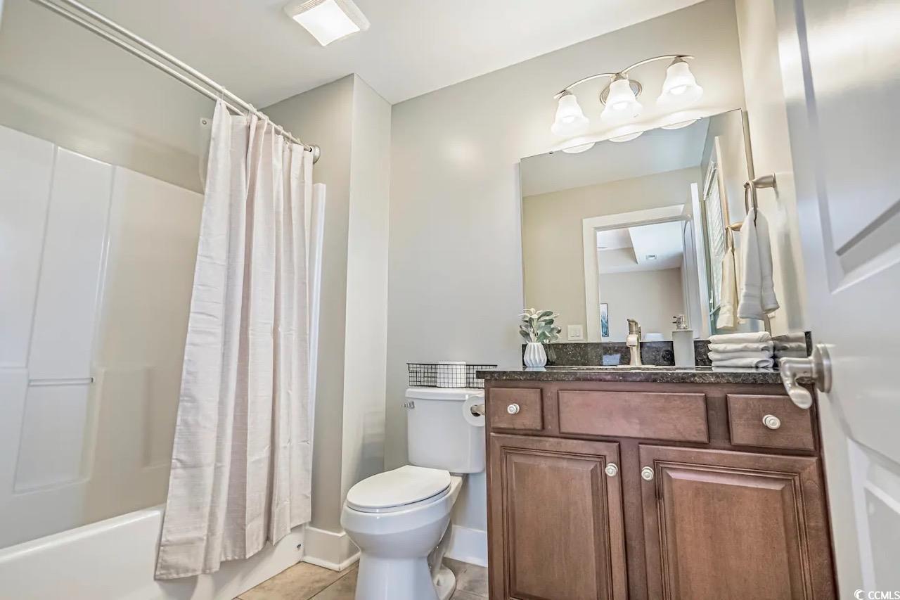 2701 Kashton Street Myrtle Beach, SC 29577 - Photo 12 of 23 Full bathroom featuring vanity, shower / tub combo with curtain, and tile patterned flooring
