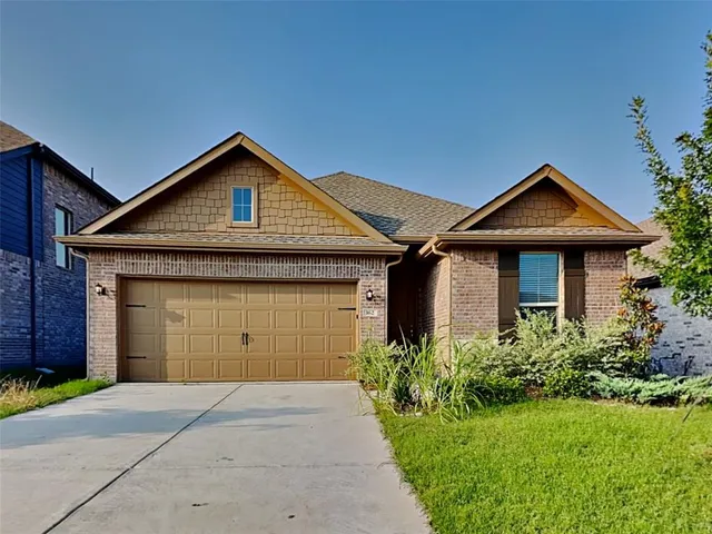 a front view of a house with a garden and garage
