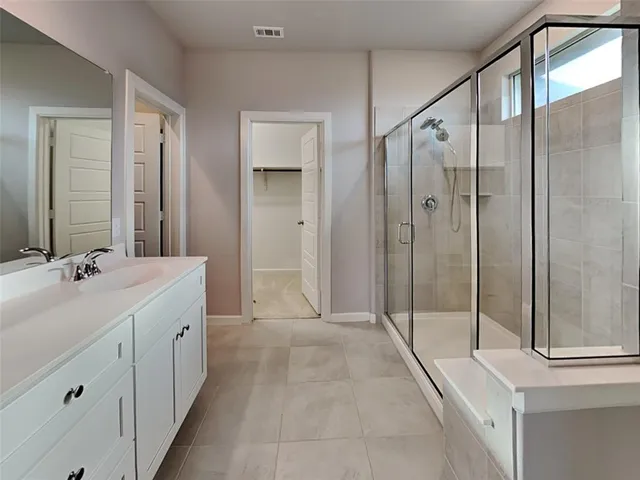 a spacious bathroom with a shower sink and mirror