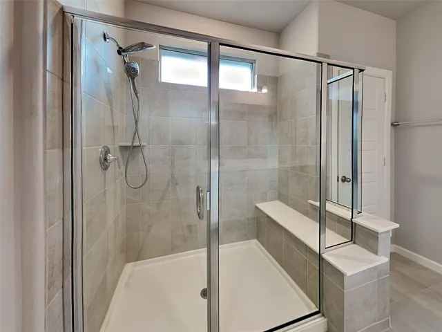 a bathroom with a shower and a glass door