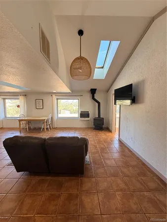 a living room with furniture a flat screen tv and a large window