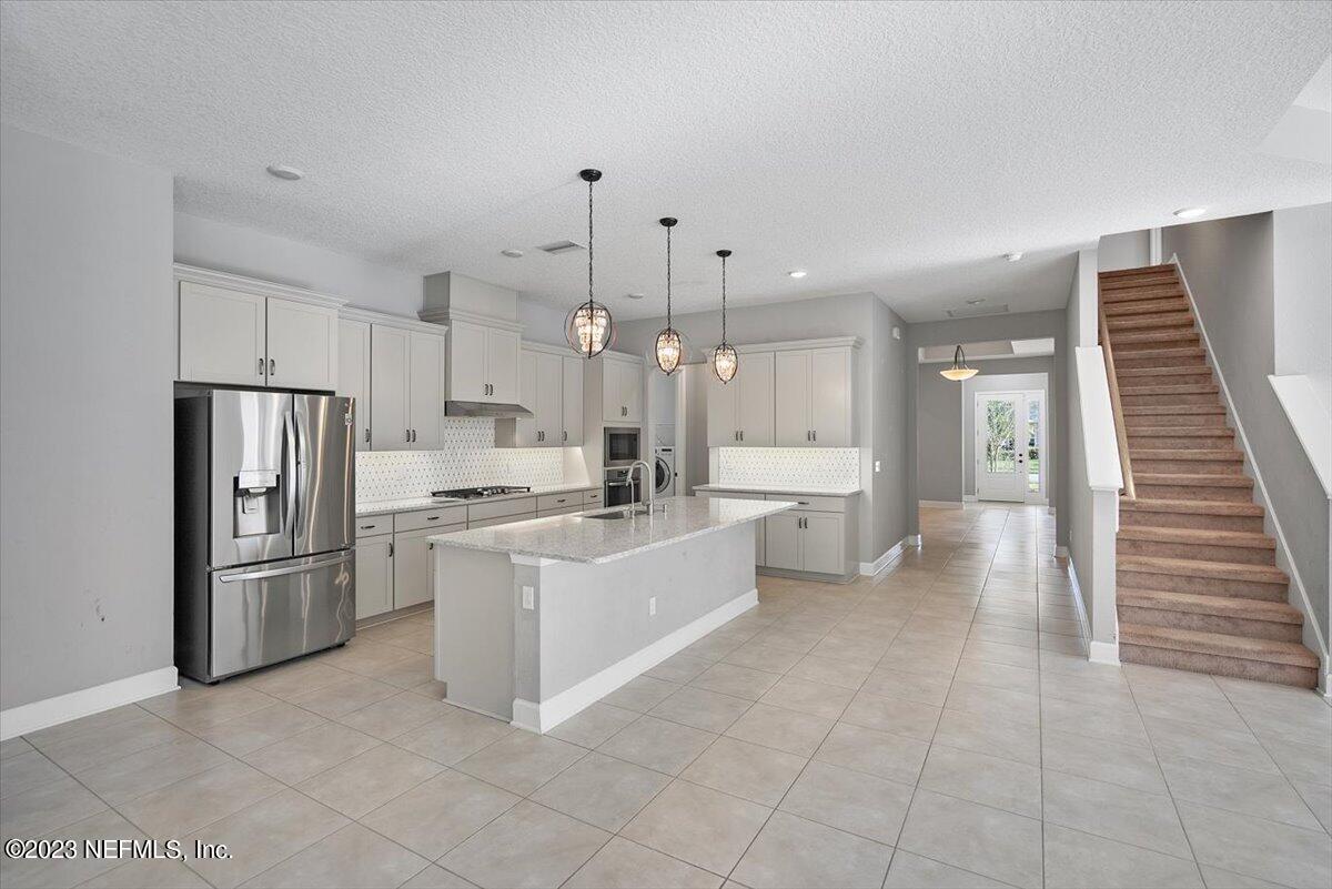26 Woodview Court Ponte Vedra, FL 32081 - Photo 11 of 71 a large kitchen with white cabinets stainless steel appliances and a center island