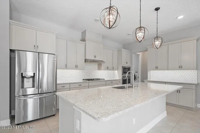 a kitchen with a sink appliances and cabinets