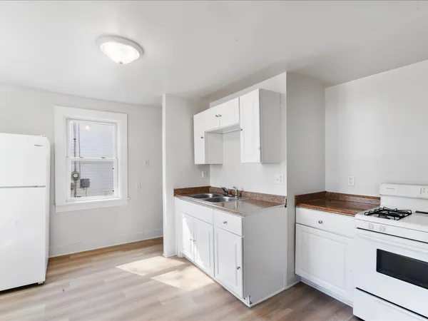 a kitchen with a stove and white cabinets