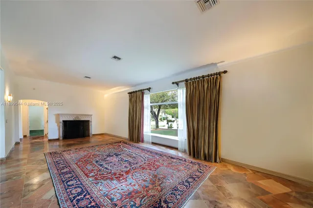 a view of a livingroom with a fireplace and window