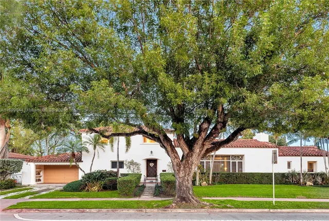 a tree in front of a white house