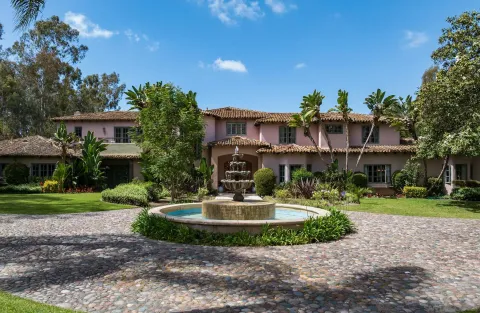 a view of a house with a yard and a fountain