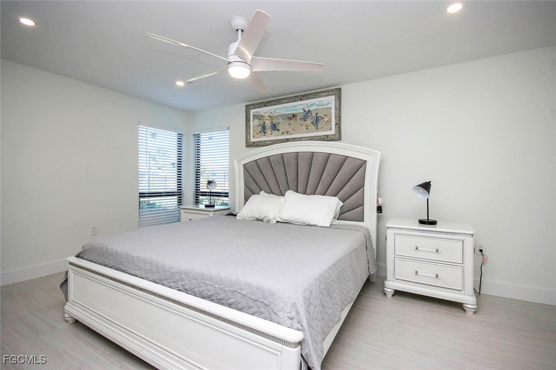 5117 Sea Bell Road, Unit E103 Sanibel, FL 33957 - Photo 11 of 24 a bedroom with a bed and a chandelier