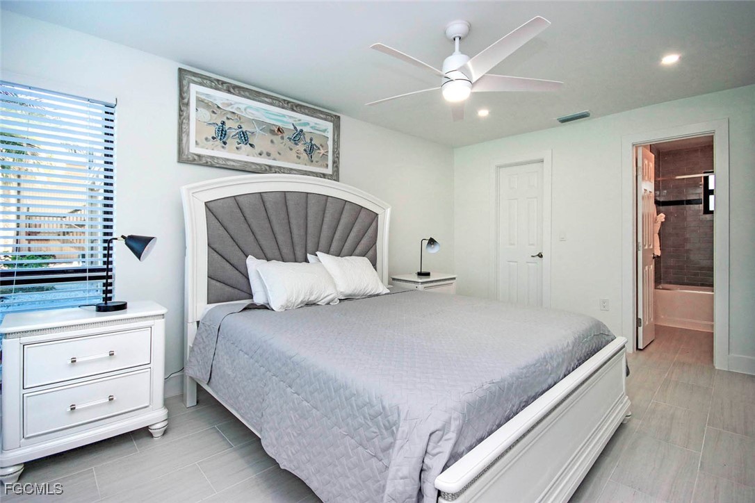 5117 Sea Bell Road, Unit E103 Sanibel, FL 33957 - Photo 12 of 24 a bedroom with a large bed and a chandelier