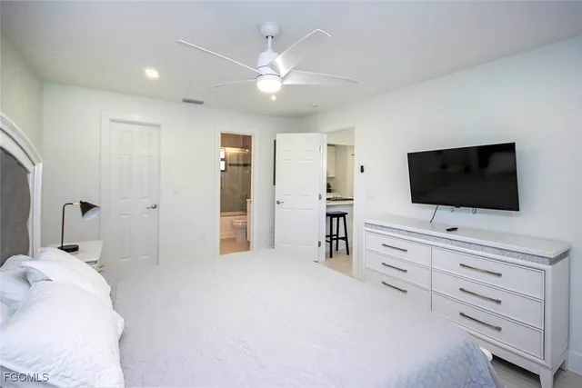 a hotel room with a flat screen tv on dresser and a flat screen tv
