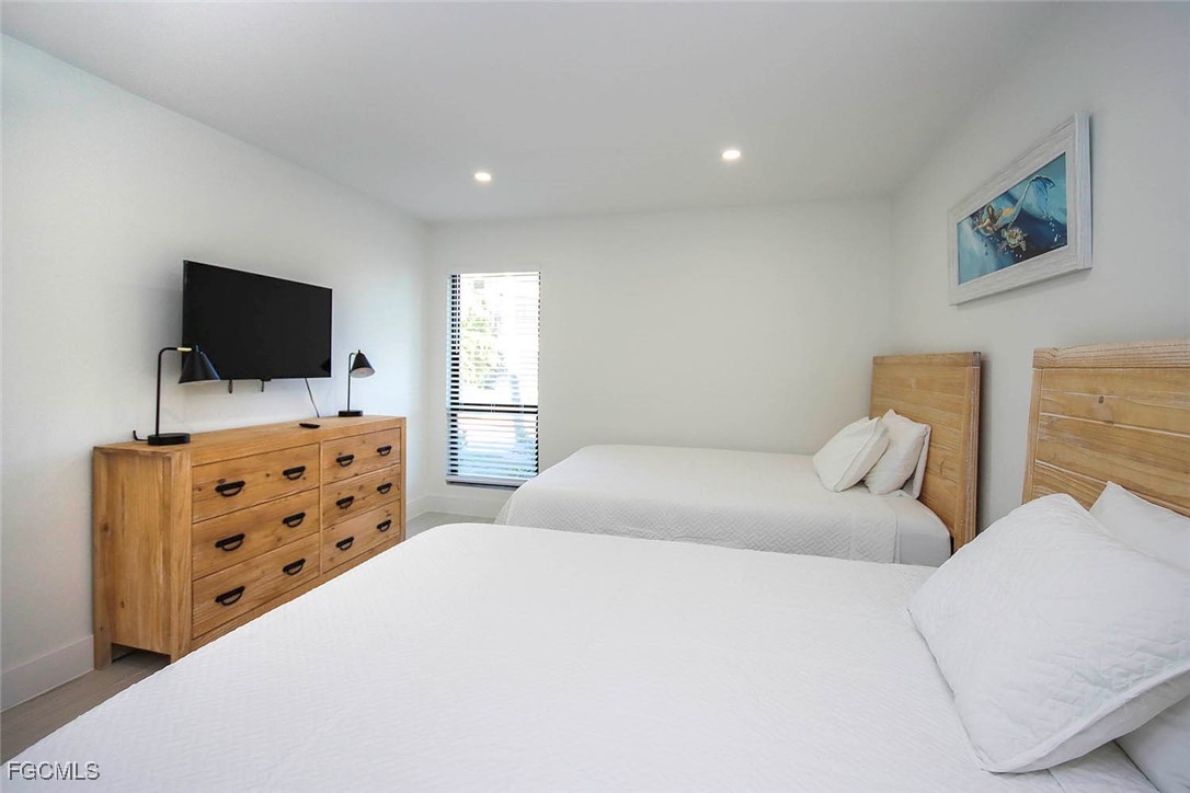 5117 Sea Bell Road, Unit E103 Sanibel, FL 33957 - Photo 17 of 24 a bedroom with furniture and flat screen tv