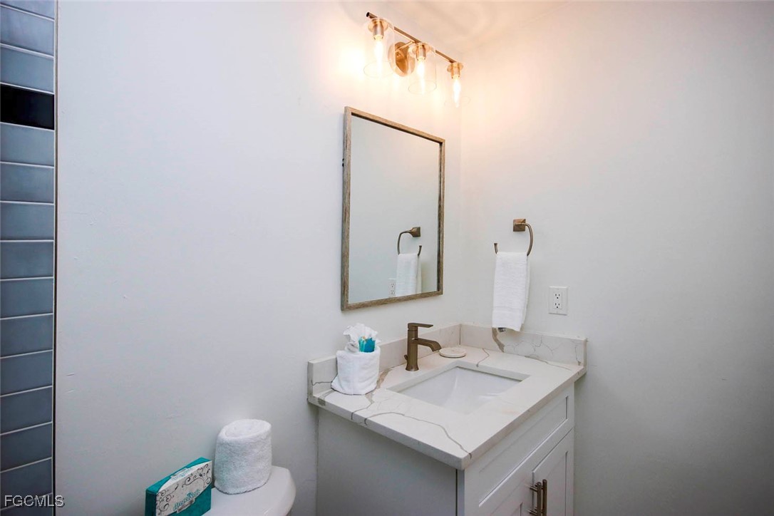 5117 Sea Bell Road, Unit E103 Sanibel, FL 33957 - Photo 19 of 24 a bathroom with a sink toilet and mirror