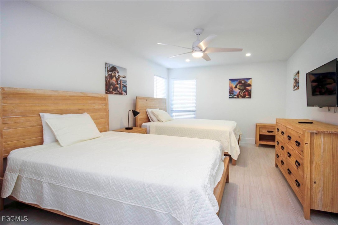 5117 Sea Bell Road, Unit E103 Sanibel, FL 33957 - Photo 20 of 24 a bedroom with bed and a flat screen tv